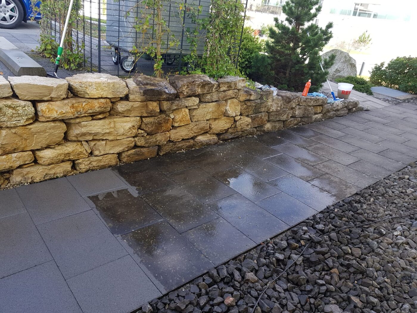 Gereinigte Plattenfläche an einer Natursteinmauer